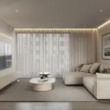 Nowoczesny salon w stylu minimalistycznym. Jasna kanapa, biały stolik kawowy, telewizor na ścianie. Ciepłe oświetlenie tworzy przytulną atmosferę.