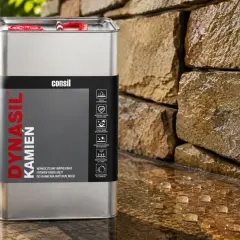 Metalowy kanister z napisem "Dynasil Kamień" obok mokrej kamiennej ściany. To nowoczesny impregnat hydrofobizujący do kamienia naturalnego.