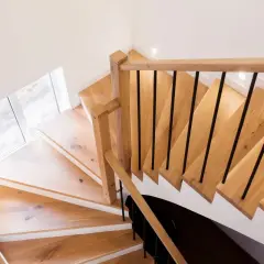 Schody z drewna i czarnej balustrady. Czyste ściany to podstawa, jak przygotować ściany do malowania.