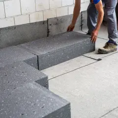 Układanie grubego, grafitowego styropianu na podłodze. To dobry wybór, jaki styropian na podłogę wybrać, by było ciepło.