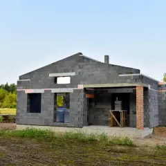 Budowa domu z keramzytu. Trwają prace nad ścianami, widoczne otwory okienne i drzwiowe. Sprawdź, jaka jest dom z keramzytu cena.