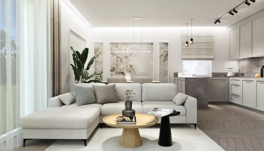 Nowoczesny salon z aneksem kuchennym, jasna sofa, drewniany stolik kawowy, dekoracje ścienne.