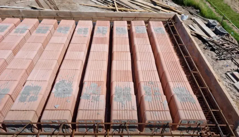 Strop ackermana w budowie. Rzędy pustaków ceramicznych ułożone na zbrojeniu, gotowe do zalania betonem.