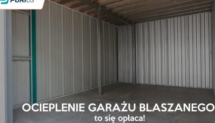 Wnętrze pustego garażu blaszanego z betonową posadzką i metalowymi ścianami.