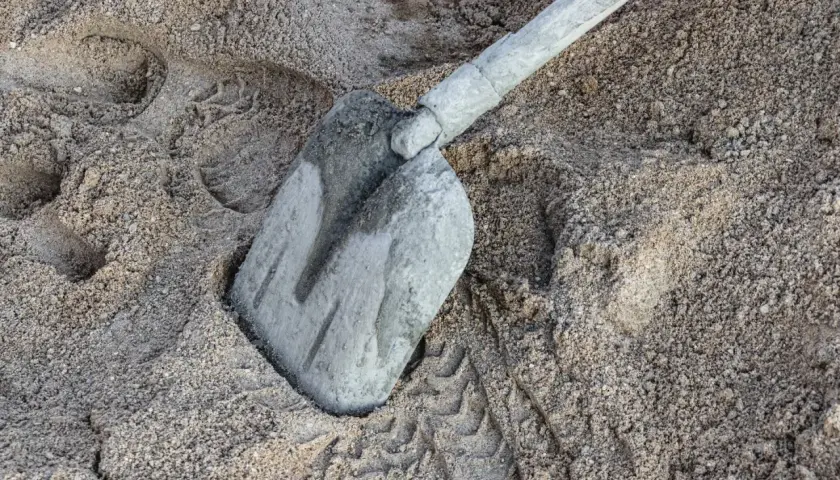 Łopata w piasku, ślady butów i pytanie: ile cementu na m3 betonu?