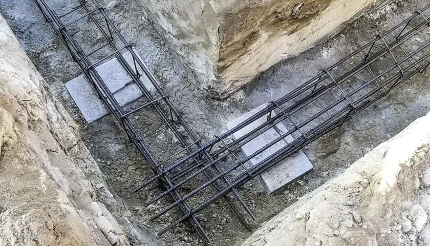 Gotowe zbrojenie fundamentu w wykopie. Stalowe pręty tworzą solidną konstrukcję, gotową na zalanie betonem.