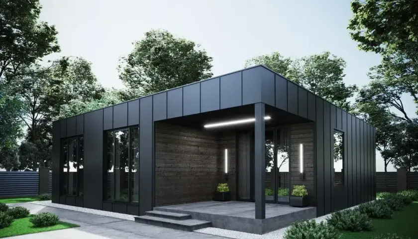 Nowoczesny dom modułowy 100m2 cena pod klucz, z czarną elewacją i drewnianymi akcentami, otoczony zielenią.