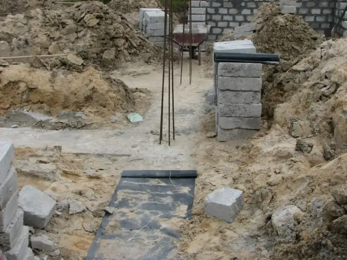 Wykonano wykopy pod fundamenty. Widać zbrojenie, betonowe bloczki i ziemię.